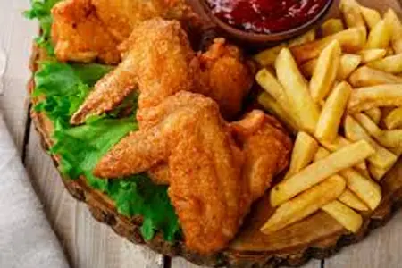 Ailes de poulet accompagnées de frites et de sauce
